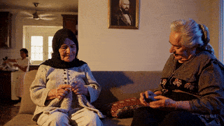 Resim açıklaması: iki yaşlı kadın birlikte oturup konuşuyor.