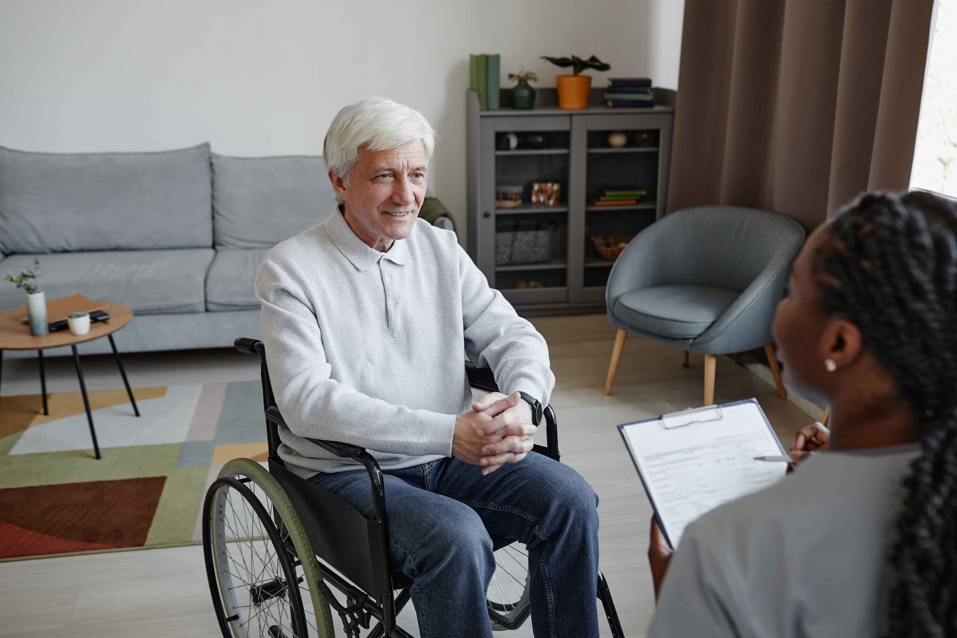 Tekerlekli sandalyede oturan beyaz saçlı engelli yaşlı adam psikososyal destek almakta